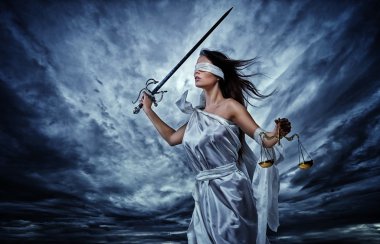 Femida, Goddess of Justice, with scales and sword wearing blindfold against dramatic stormy sky clipart
