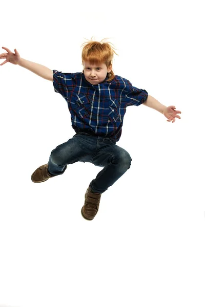 Little funny redhead boy in shirt and jeans jumping — Stock Photo, Image