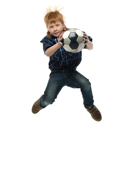 Petit garçon rousse drôle avec ballon de football sautant — Photo