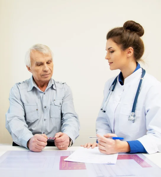 Senior bei Arzttermin mit Pillen — Stockfoto