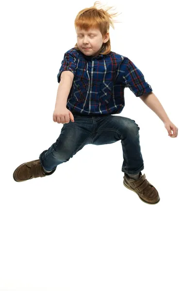 Poco divertido pelirrojo chico en camisa y jeans saltar —  Fotos de Stock