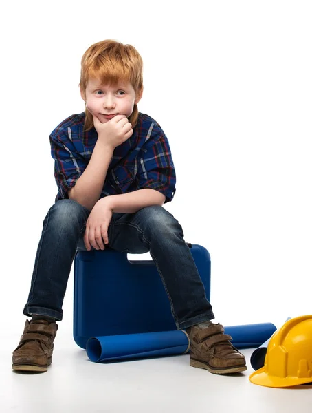 Piccolo ragazzo meccanico annoiato seduto su una cassetta degli attrezzi — Foto Stock