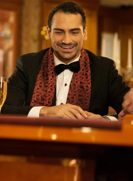 Tablo bir casino kumar arkasında takım elbiseli iki genç adam — Stok fotoğraf