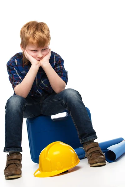 Piccolo ragazzo meccanico annoiato seduto su una cassetta degli attrezzi — Foto Stock