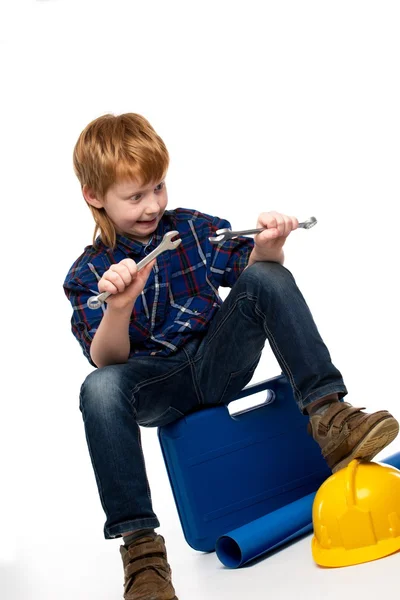 Vicces szerelő kisfiú ül az eszköztár csavarkulcs eszközökkel — Stock Fotó