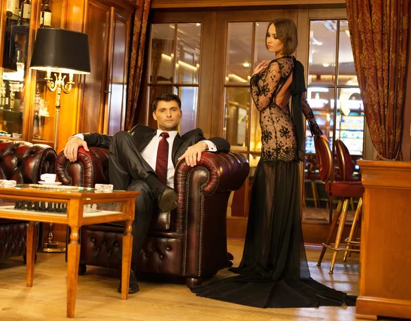 Elegant couple in formal dress in luxury cabinet interior — Stock Photo, Image