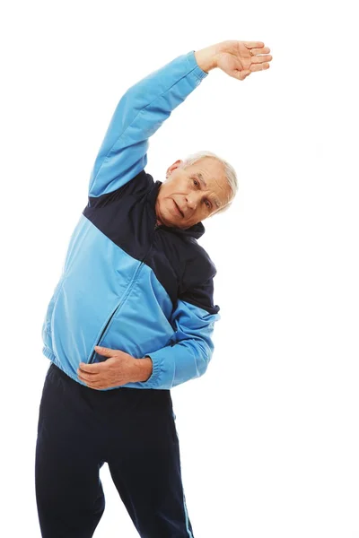 Старший чоловік у тренувальному костюмі робить вправи для розтягування — стокове фото
