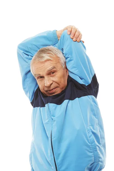 Homem sênior em terno de treinamento fazendo exercícios de alongamento de aquecimento — Fotografia de Stock
