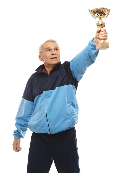 Senior man in training suit with a prize cup — Stock Photo, Image