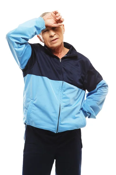 Homem idoso em terno de treinamento sentindo dor de cabeça enxaquecas — Fotografia de Stock