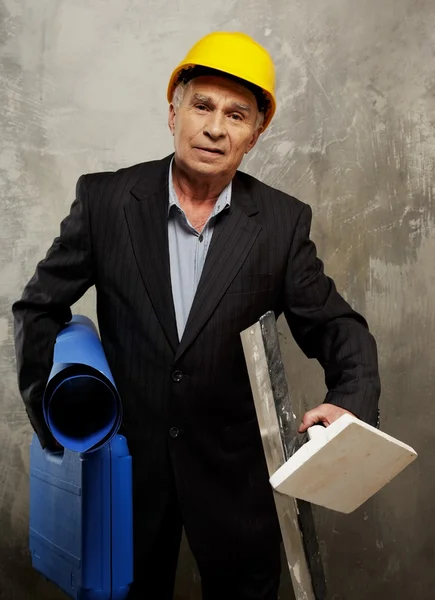 Senior man engineer with construction site plan and different tools — Stock Photo, Image