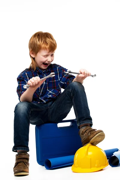 Funny little mechanic boy with wrench tools sitting on toolbox — Stock Photo, Image