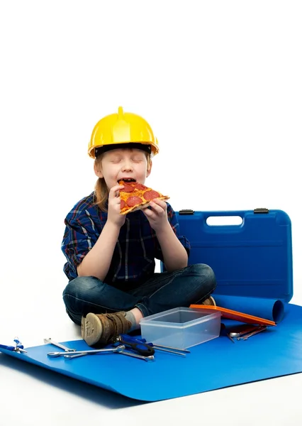 Pouco engraçado mecânico menino comer pizza entre as ferramentas — Fotografia de Stock