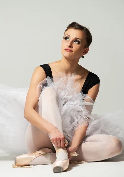 Vackra unga ballerina dansare sitter på ett golv — Stockfoto