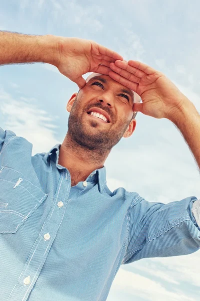 Positieve man van middelbare leeftijd buiten tegen blauwe hemel — Stockfoto