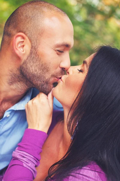 Счастливая улыбающаяся пара средних лет целуется на открытом воздухе — стоковое фото