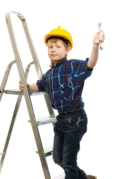 Niño en casco protector con llave inglesa en una escalera — Foto de Stock