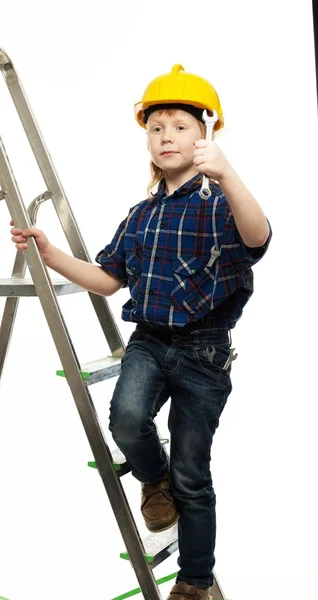 Kleine jongen in beschermende helm met moersleutel gereedschap op een ladder — Stockfoto