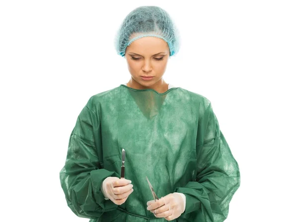 Молода жінка лікар з хірургічним скальпелем і ножицями — стокове фото