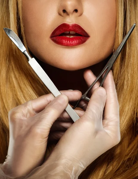 Händer med plastikkirurgi verktyg nära ung kvinna ansikte — Stockfoto