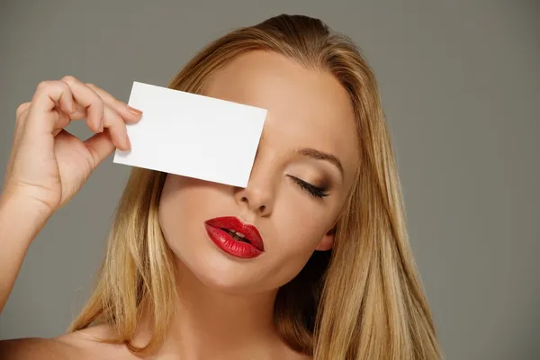 Cara de mujer joven con labios rojos seductores y papel en blanco con espacio de copia — Foto de Stock