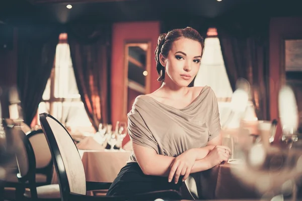 Όμορφη νεαρή γυναίκα που μόνο σε μια πολυτελή εσωτερικό εστιατόριο — Φωτογραφία Αρχείου