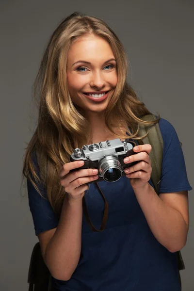 Позитивная молодая женщина с длинными волосами и голубыми глазами держит винтажный стиль камеры — стоковое фото