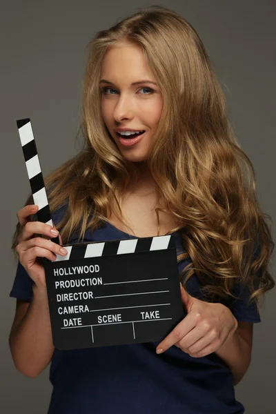 Молода жінка з довгим волоссям і блакитними очима тримає кінематографічну дошку — стокове фото