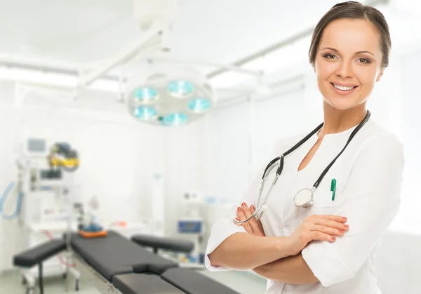 Jovem morena positiva médico mulher na sala de cirurgia interior — Fotografia de Stock