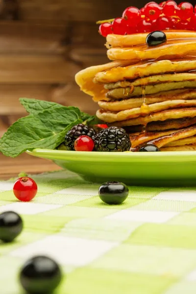 Tasty pancakes with maple syrup and fresh berries on a plate — Stock Photo, Image