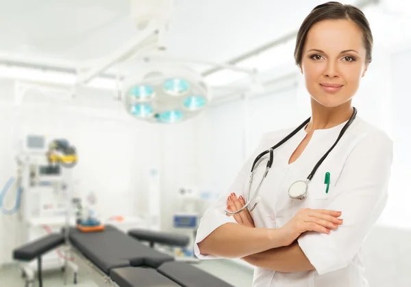 Jovem morena positiva médico mulher na sala de cirurgia interior — Fotografia de Stock