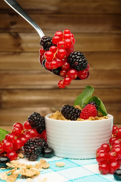 Gesundes Frühstück mit Müsli und Beeren auf Tischdecke im ländlichen Holzinterieur — Stockfoto