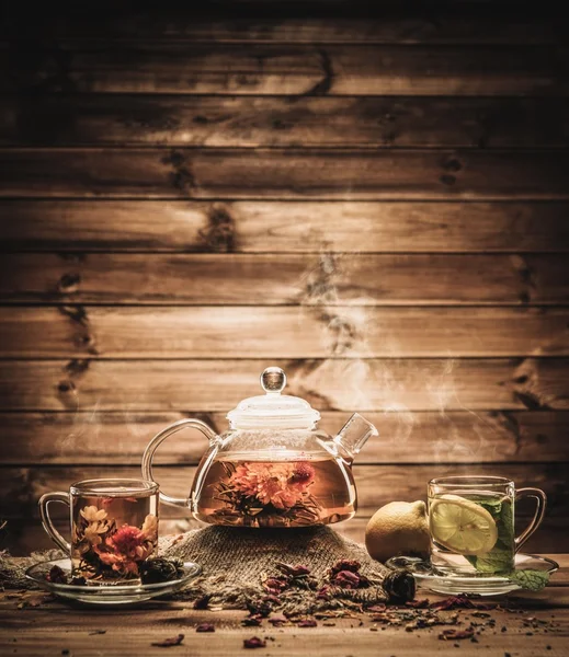 Tetera y tazas de vidrio con té sobre fondo de madera —  Fotos de Stock