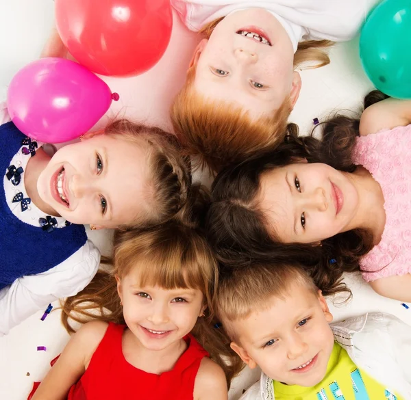 Kruppe glücklicher Kinder, die im Kreis liegen — Stockfoto