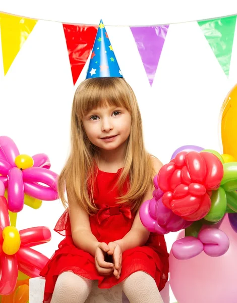 Klein meisje in een rode jurk zittend op geschenkdozen — Stockfoto