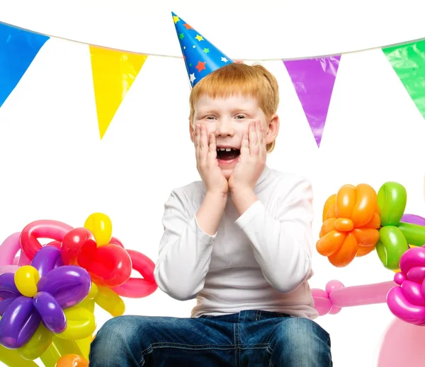 Menino ruivo surpreso entre balões de aniversário — Fotografia de Stock