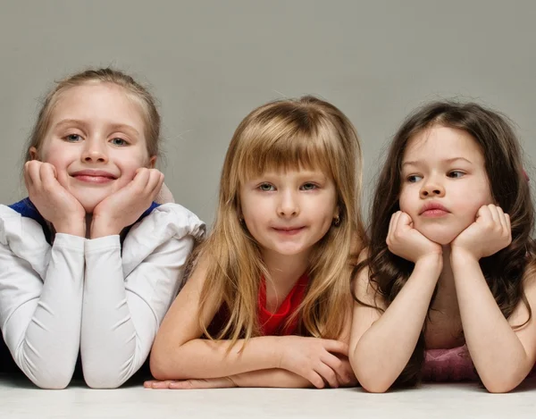 Drie kleine meisjes geïsoleerd op grijze achtergrond — Stockfoto