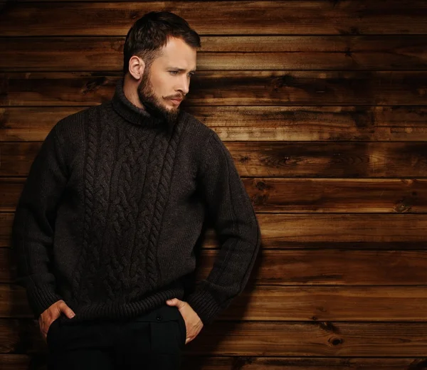 Schöner Mann mit Strickjacke im ländlichen Holzhaus-Interieur — Stockfoto