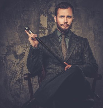 Handsome well-dressed with stick sitting in leather chair  clipart
