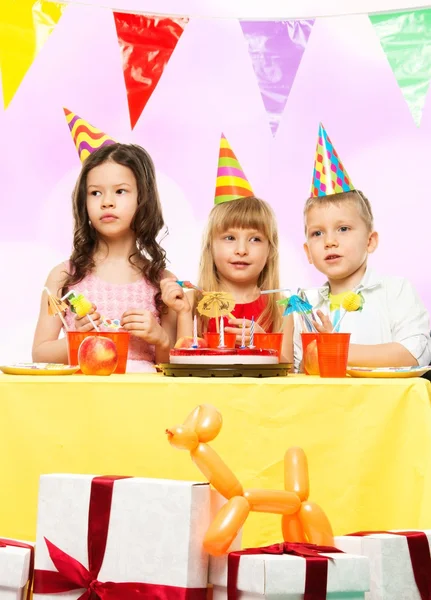 Grupo de niños felices celebrando su cumpleaños detrás de la mesa — Foto de Stock