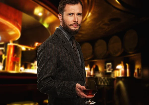 A kabát szép jól öltözött férfi, pohár ital, étterem belső — Stock Fotó