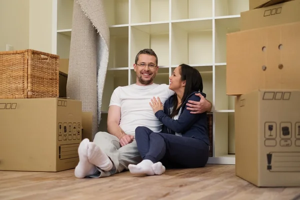 Joven pareja positiva entre cajas en su nuevo hogar —  Fotos de Stock
