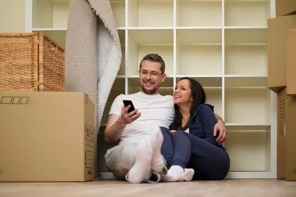 Joven pareja positiva entre cajas en su nuevo hogar —  Fotos de Stock
