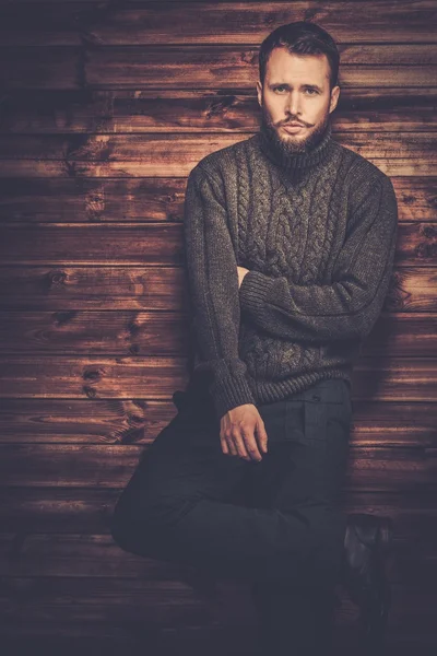 Schöner Mann mit Strickjacke im ländlichen Holzhaus-Interieur — Stockfoto