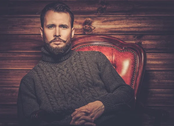 Handsome man wearing cardigan in wooden rural house interior — Stock Photo, Image