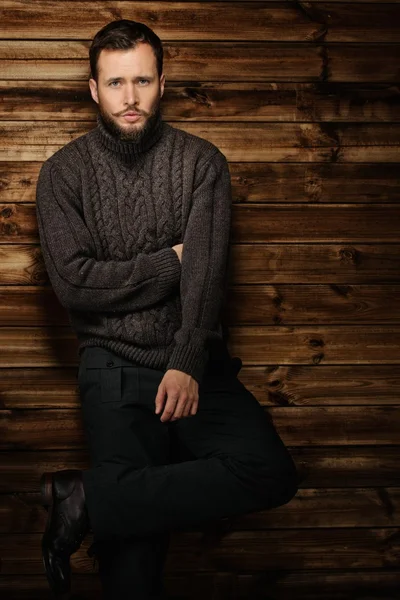 Schöner Mann mit Strickjacke im ländlichen Holzhaus-Interieur — Stockfoto