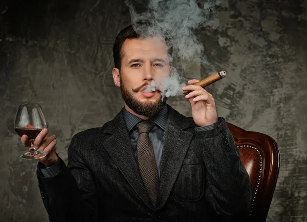 Handsome well-dressed with glass of beverage and cigar — Stock Photo, Image