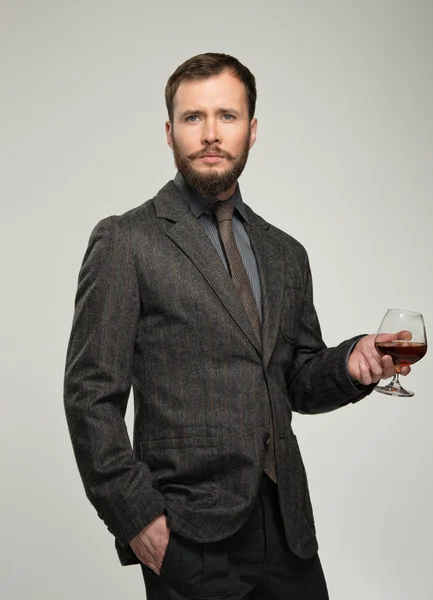 Handsome well-dressed man in jacket with glass of beverage — Stock Photo, Image