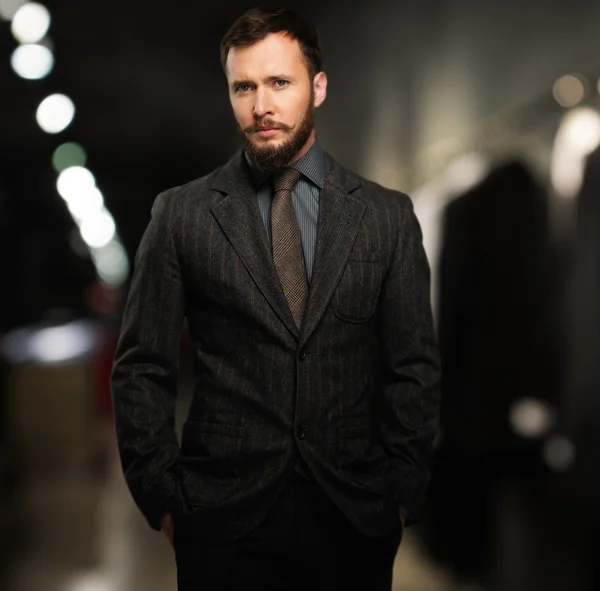 Hombre guapo y bien vestido con barba en una tienda de ropa —  Fotos de Stock