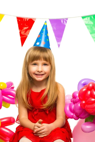 Klein meisje in een rode jurk zittend op geschenkdozen — Stockfoto